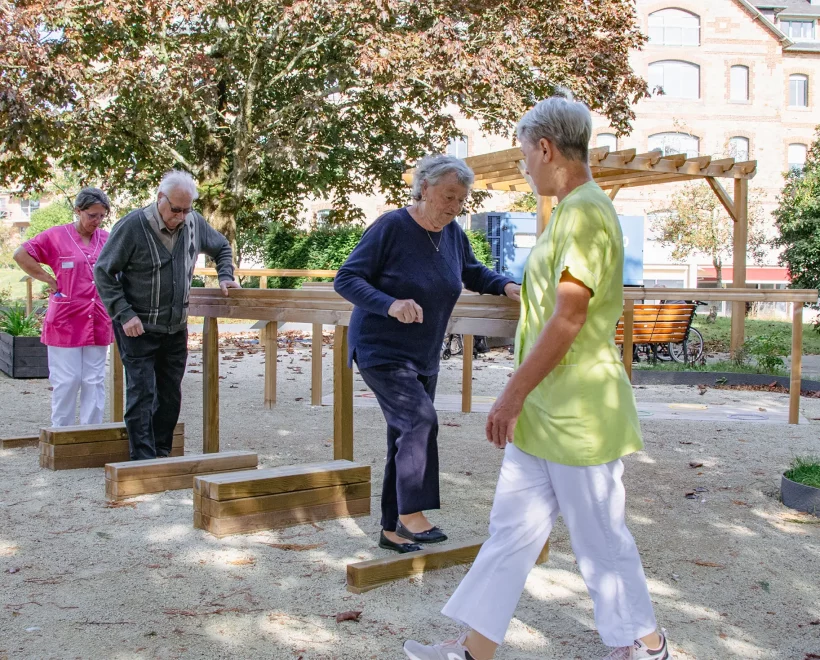 résidents qui marchent sur le parcours de mobilité dans le jardin